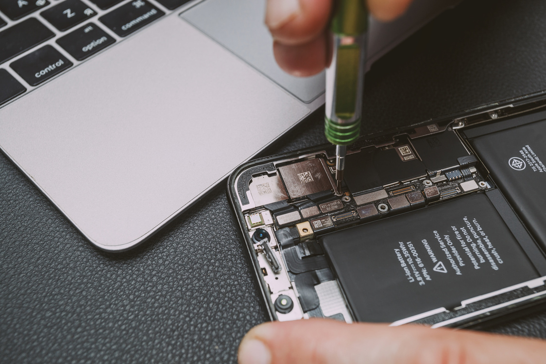 Técnico especializado realizando manutenção em celular